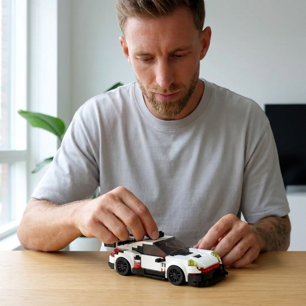 Hände beim Zusammenbau eines BrickCars Klemmbaustein-Modells am Abend